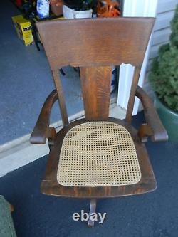 Antique Tiger Oak Mission Swivel Office Bankers Chair Cane Seat glare on pic